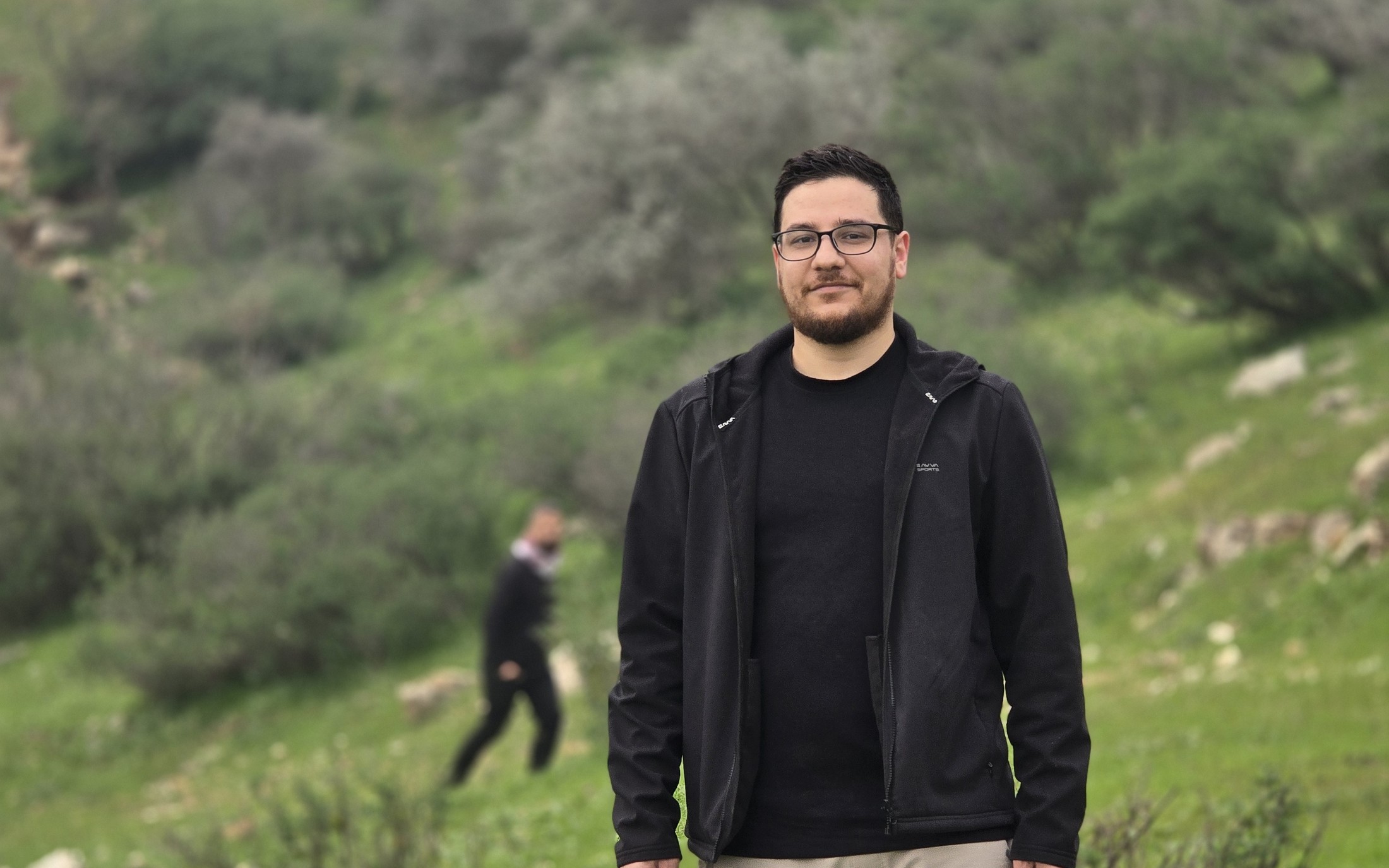 Mustafa Azad standing on a green hillside.